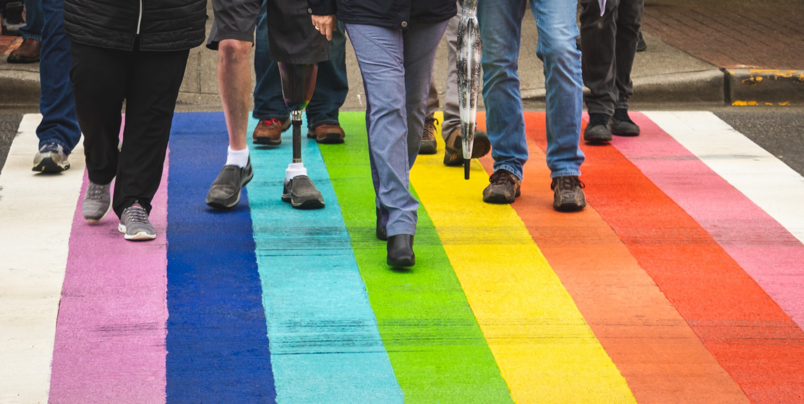 Rainbow crosswalk with people walking