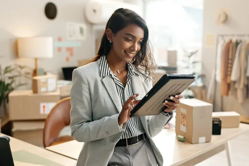 Small business owner managing inventory and shipments on a tablet.