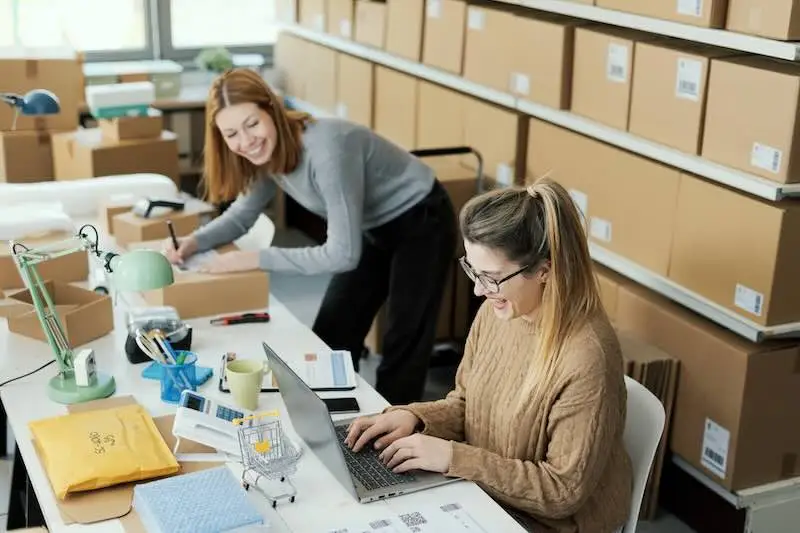 women-owned-img Women-owned small business team packing orders and managing shipments at a workspace.