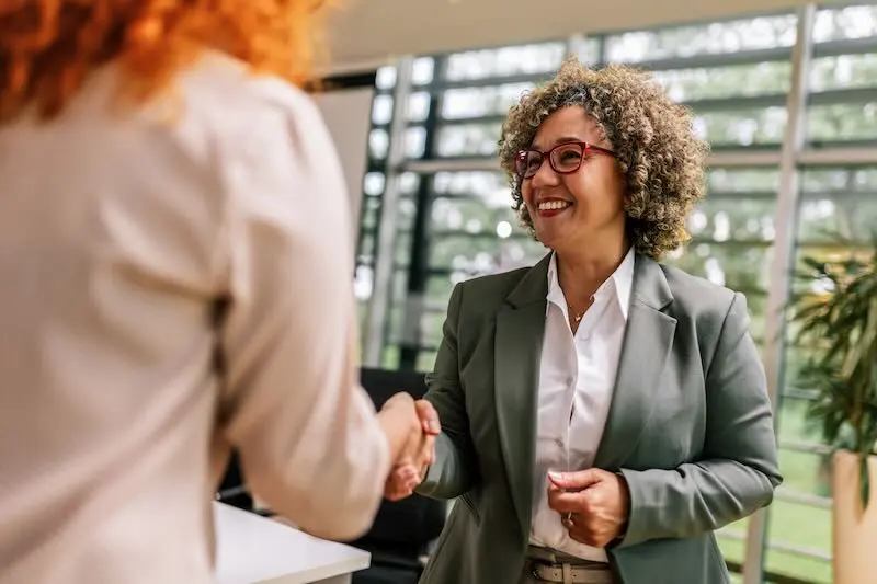 zero-sales-img Smiling business woman shaking hands with a client in an office.